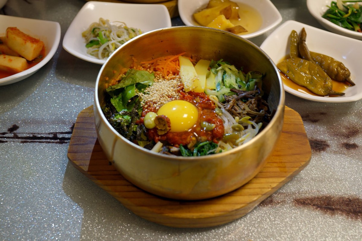 A brass bowl of Jeonju bibimbap surrounded by side dishes, the signature meal of Korea's food capital